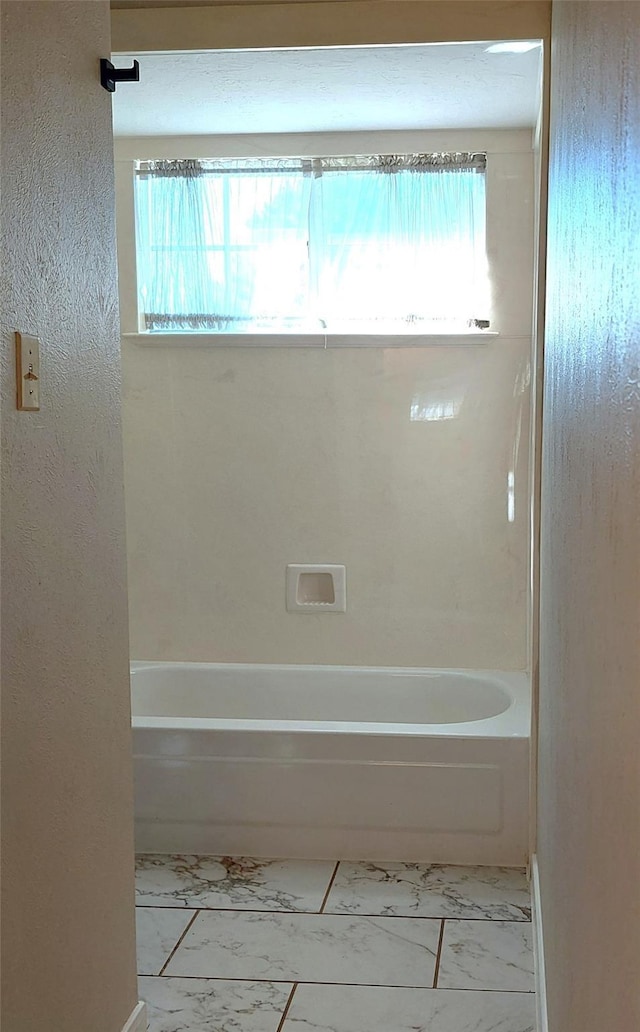 full bath featuring plenty of natural light, bathing tub / shower combination, and marble finish floor