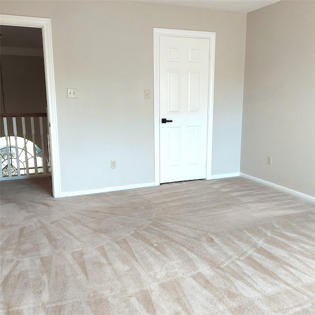 empty room featuring baseboards and carpet