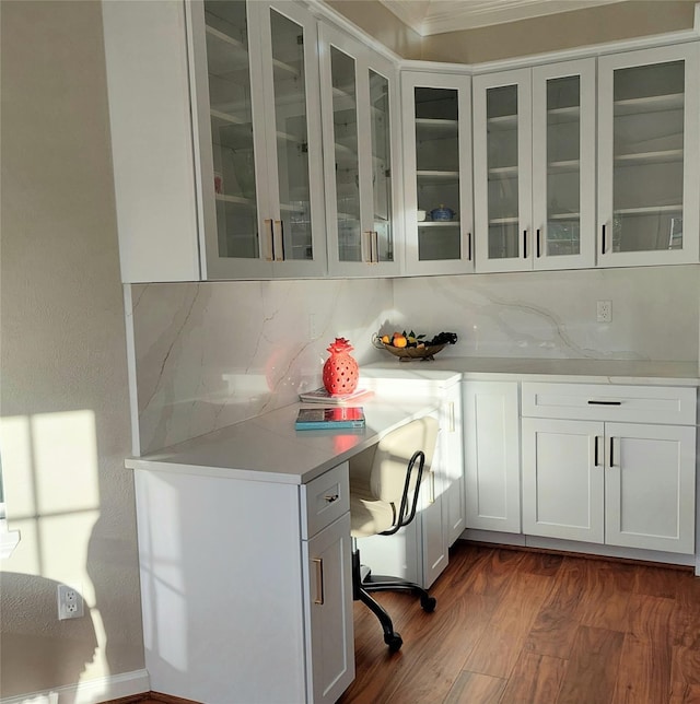 interior space featuring tasteful backsplash, glass insert cabinets, dark wood finished floors, light countertops, and white cabinetry