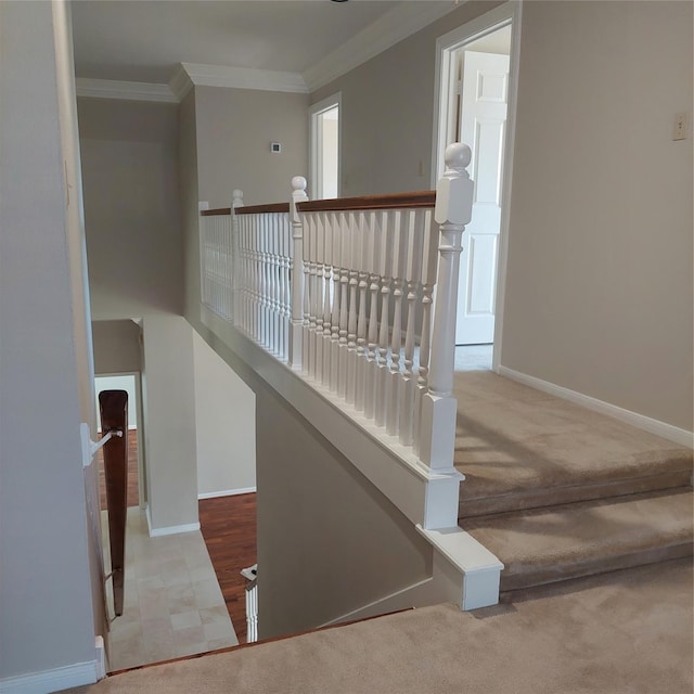 hall with crown molding, an upstairs landing, baseboards, and carpet floors