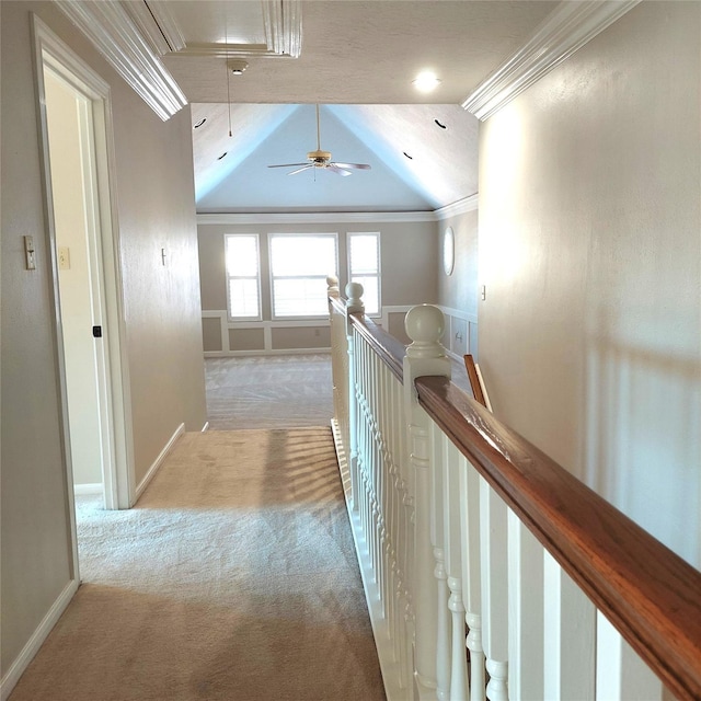 hall featuring an upstairs landing, ornamental molding, carpet flooring, baseboards, and attic access