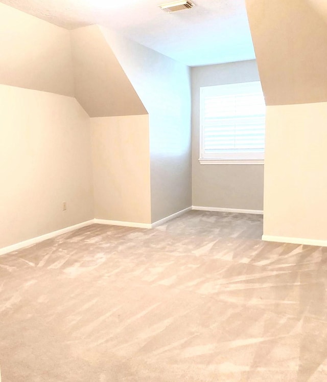 bonus room featuring lofted ceiling, visible vents, baseboards, and carpet floors