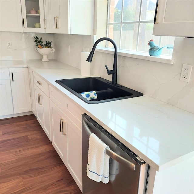 kitchen with tasteful backsplash, dishwasher, dark wood-style floors, white cabinetry, and a sink