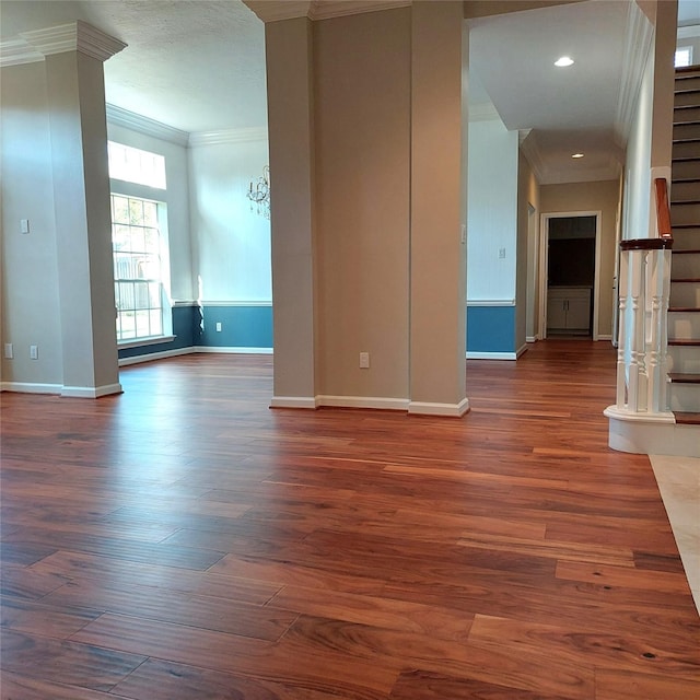 spare room featuring stairway, wood finished floors, baseboards, recessed lighting, and crown molding