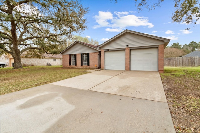 ranch-style home featuring driveway, fence, a front yard, an attached garage, and brick siding