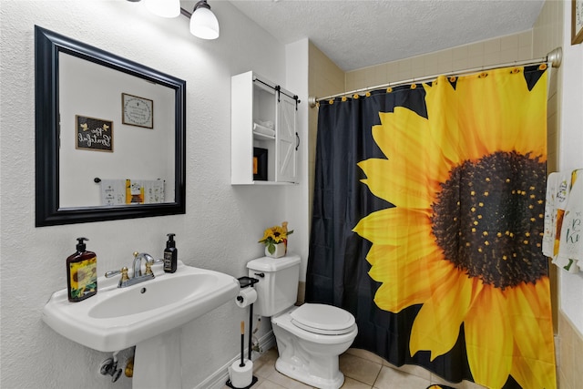 full bath with toilet, a sink, a textured ceiling, a shower with shower curtain, and tile patterned flooring