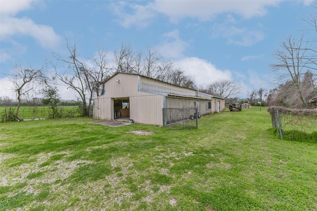 view of yard featuring an outbuilding, an outdoor structure, fence, and a detached garage