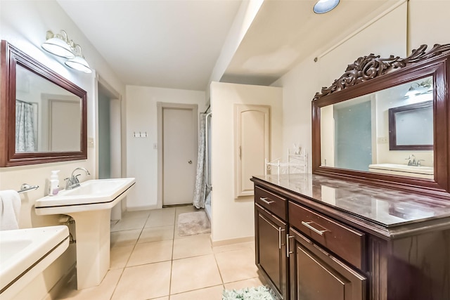 full bathroom with tile patterned flooring, two sinks, and baseboards