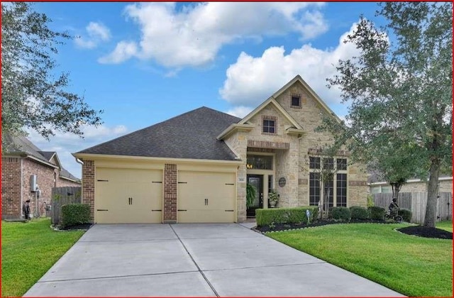 traditional home featuring a garage, driveway, a front lawn, and fence