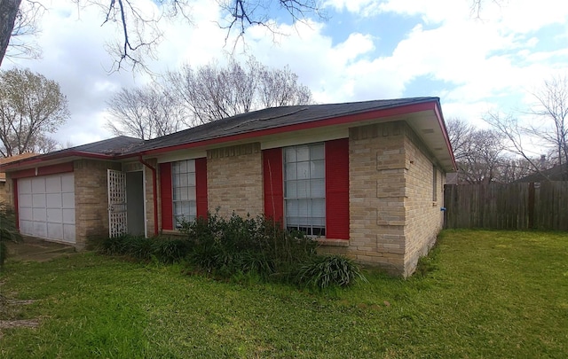 view of home's exterior with a garage, brick siding, a lawn, and fence