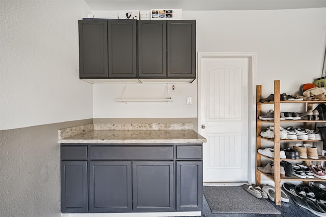 kitchen with light stone counters and gray cabinetry