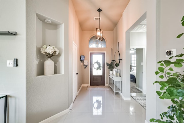 foyer with light tile patterned floors, baseboards, and visible vents