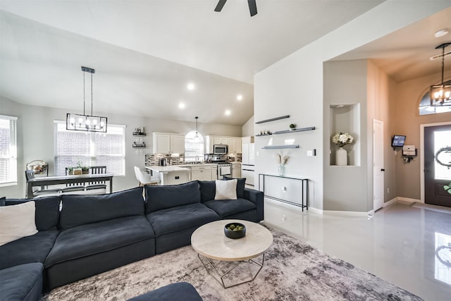 living area featuring light tile patterned floors, lofted ceiling, recessed lighting, baseboards, and ceiling fan with notable chandelier