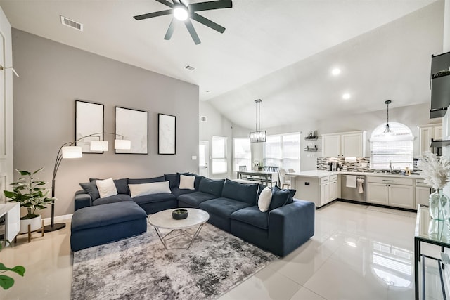 living room with light tile patterned floors, visible vents, vaulted ceiling, and a ceiling fan