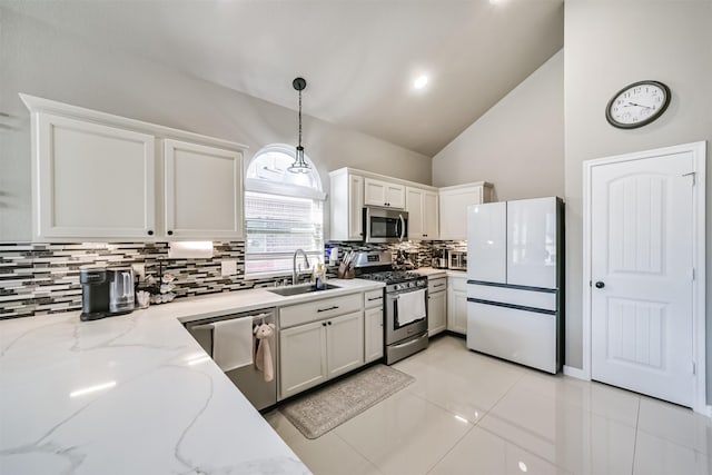 kitchen featuring decorative light fixtures, a sink, stainless steel appliances, white cabinetry, and backsplash