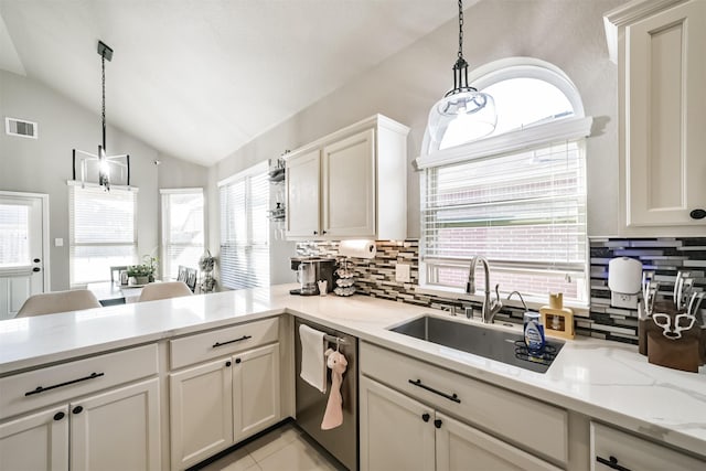 kitchen featuring a peninsula, a sink, visible vents, vaulted ceiling, and dishwasher