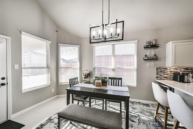 dining area featuring vaulted ceiling, plenty of natural light, and baseboards