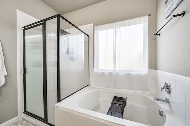 full bathroom featuring a stall shower and a garden tub