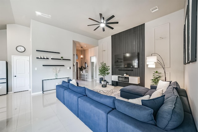 living room with vaulted ceiling, light tile patterned floors, visible vents, and a ceiling fan