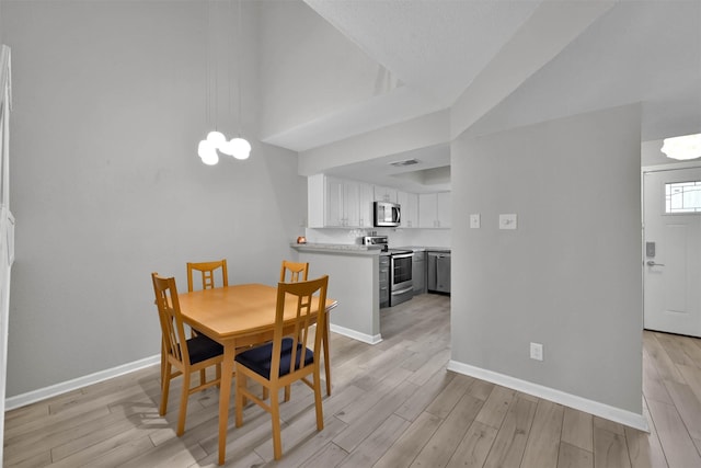 dining space featuring light wood-style floors, visible vents, and baseboards