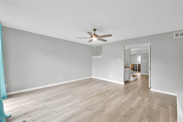 spare room featuring baseboards, visible vents, ceiling fan, and light wood finished floors