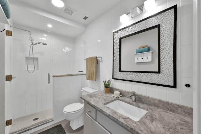 full bathroom with a stall shower, visible vents, toilet, vanity, and tile walls