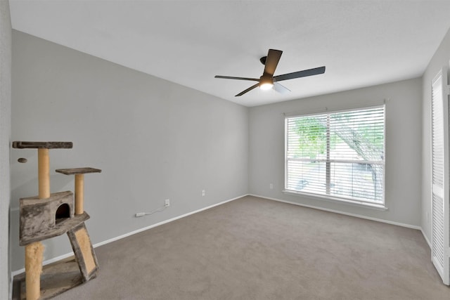 spare room with carpet floors, ceiling fan, and baseboards