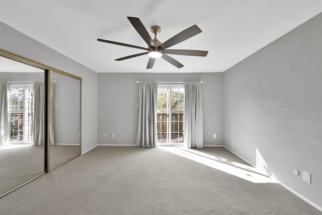 unfurnished bedroom with baseboards, carpet, a ceiling fan, and a closet