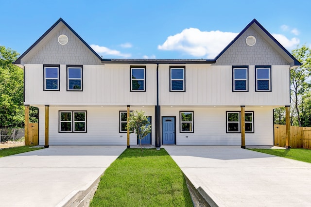 view of front facade with a patio area, fence, and a front lawn