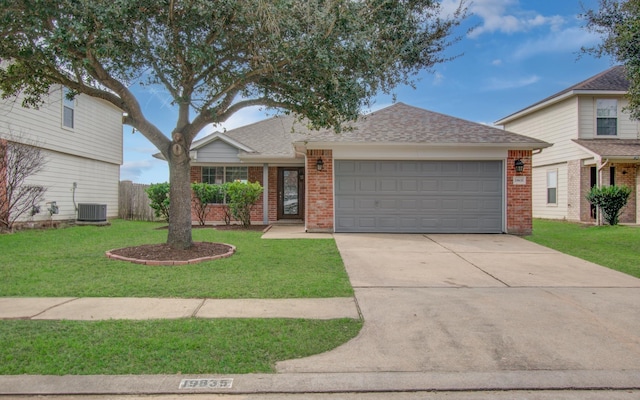 view of front of home featuring cooling unit, a garage, brick siding, driveway, and a front yard