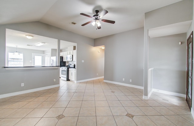 unfurnished living room with vaulted ceiling, light tile patterned flooring, ceiling fan, and baseboards