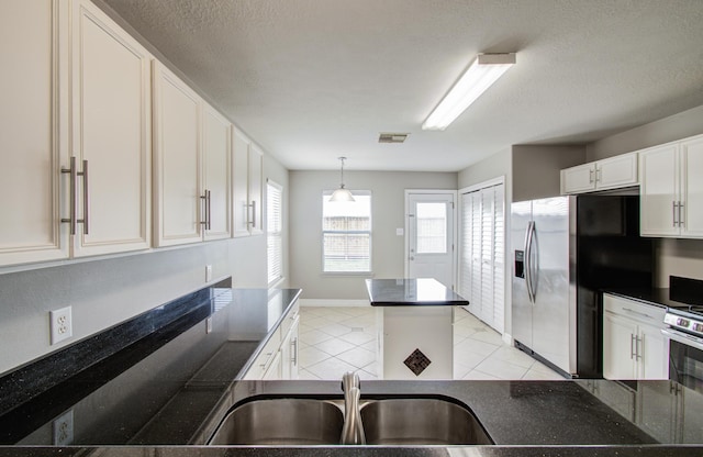 kitchen with white cabinets, visible vents, stainless steel refrigerator with ice dispenser, and a textured ceiling