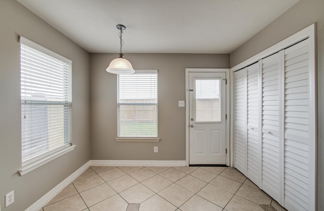 interior space with light tile patterned floors and baseboards