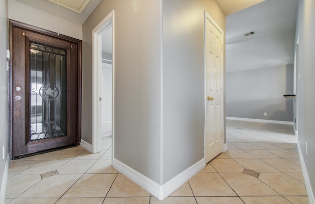 foyer with light tile patterned floors, baseboards, and visible vents