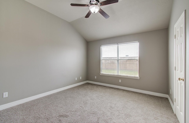 spare room featuring ceiling fan, baseboards, vaulted ceiling, and light colored carpet