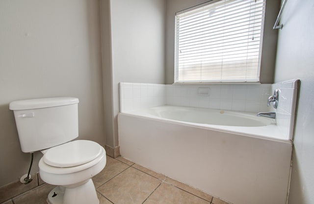 bathroom featuring toilet, tile patterned flooring, and a bath