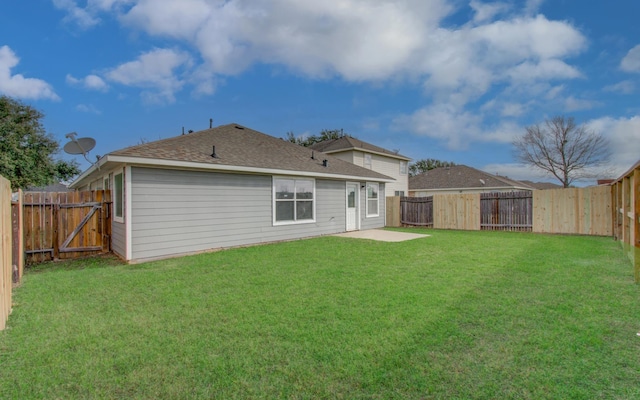 rear view of house with a yard, roof with shingles, a patio area, and a fenced backyard