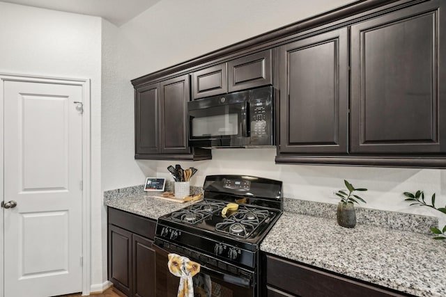 kitchen with dark brown cabinetry, black appliances, and light stone counters