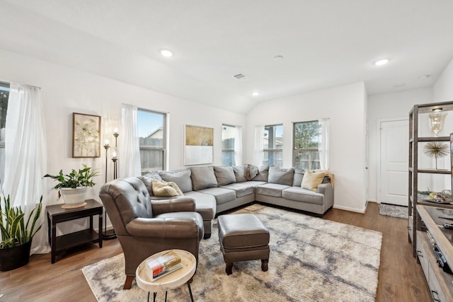 living area with lofted ceiling, recessed lighting, wood finished floors, visible vents, and baseboards