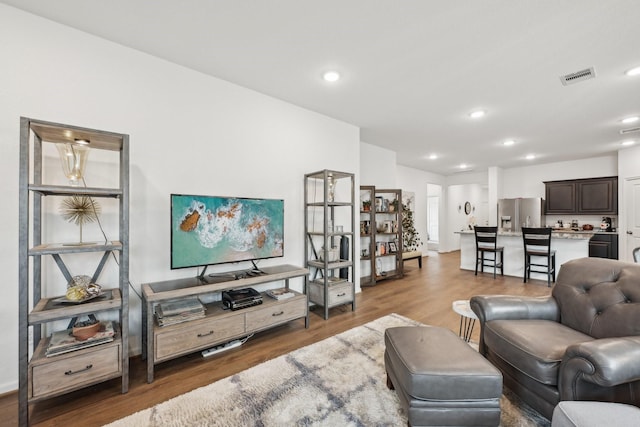 living room with visible vents, wood finished floors, and recessed lighting