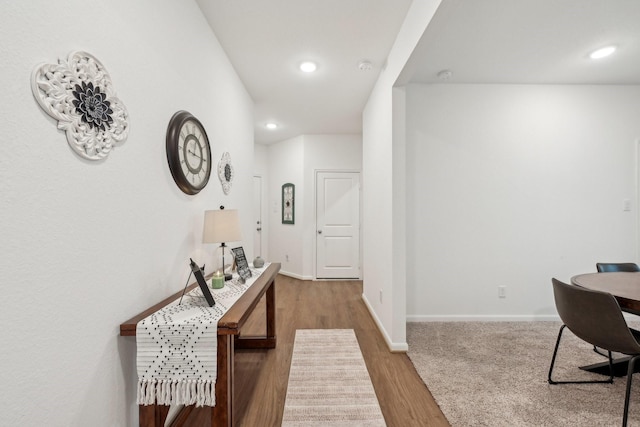 corridor with baseboards, wood finished floors, and recessed lighting