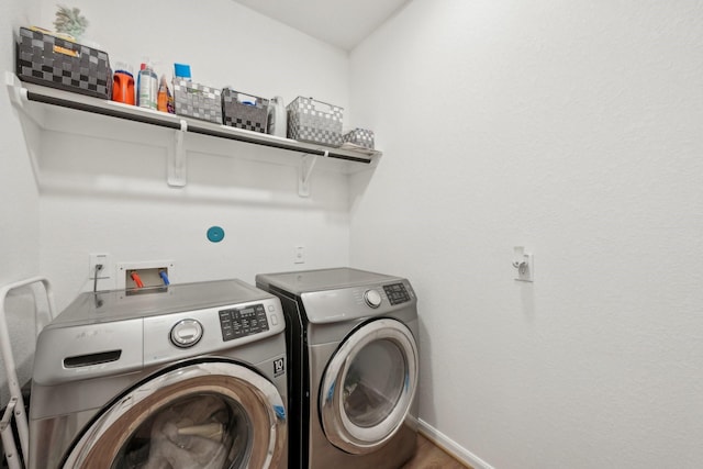 laundry area with laundry area, washer and clothes dryer, and baseboards