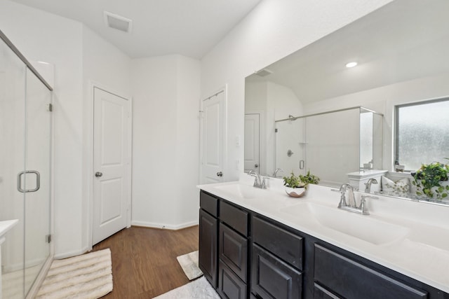 full bath with a stall shower, a sink, and wood finished floors