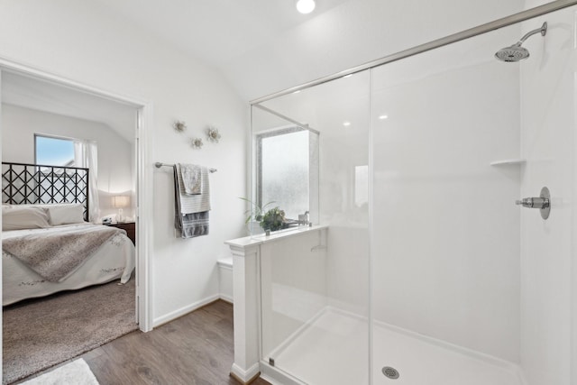 ensuite bathroom with a stall shower, ensuite bath, and wood finished floors