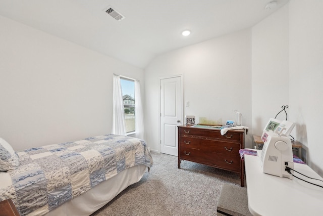 carpeted bedroom with visible vents and vaulted ceiling