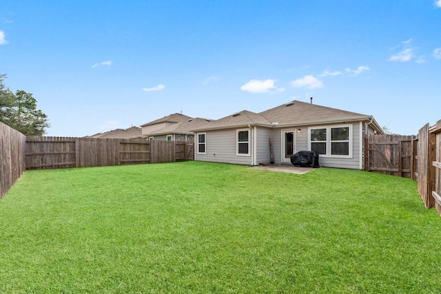 rear view of house featuring a fenced backyard and a yard