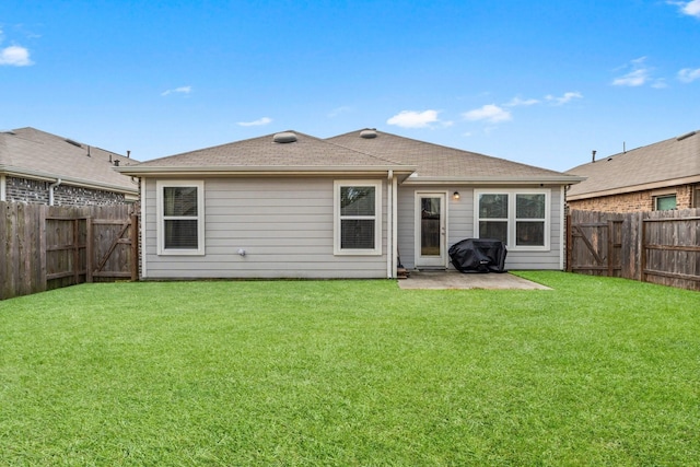 rear view of house featuring a yard, a patio area, and a fenced backyard