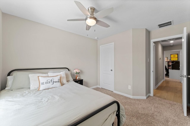 carpeted bedroom featuring visible vents, ceiling fan, and baseboards