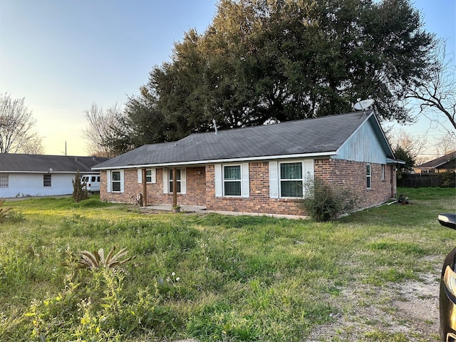 single story home featuring brick siding and a front yard