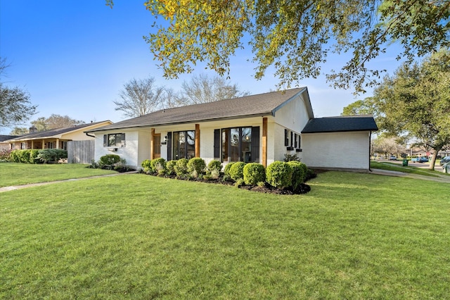 ranch-style home featuring a front yard and brick siding